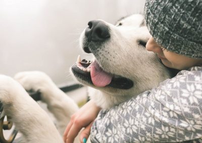 Frau mit glücklichem Hund im Arm